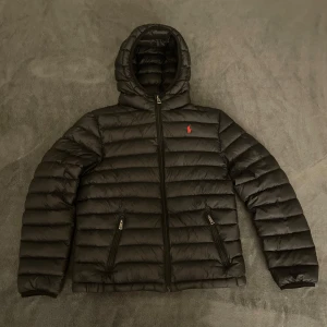 Svart dunjacka från Polo Ralph Lauren - Hej 👋 Säljer en snygg svart dunjacka från Polo Ralph Lauren i mycket bra skick. Storlek 14-16. Tveka inte på att fråga