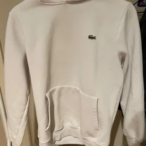 Lacoste hoodie  - Lacoste hoodie i vit färg. Storlek M men sitter mer som S. Fint skick. Tveka inte på att skriva vid funderingar.