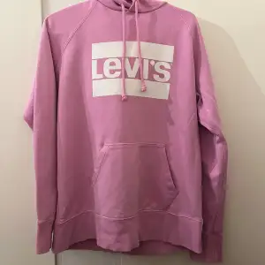 Säljer en superfin rosa hoodie från Levi's i mycket bra skick. Den har en stor ficka fram och en justerbar huva med dragsko. Perfekt för en avslappnad stil och passar bra till både jeans och leggings. Stor logga på bröstet ger en cool look!