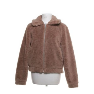 Brun teddyjacka med dragkedja - Mysig brun teddyjacka perfekt för kyliga dagar. Den har en dragkedja framtill och långa ärmar. Jackan är i bra skick och passar perfekt för höst och vinter. Den är supermjuk och håller dig varm och bekväm.