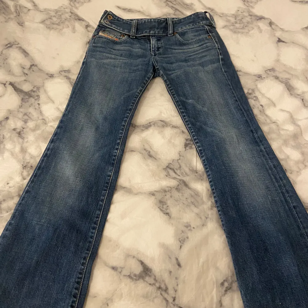 Säljer ett par snygga lågmidjade blå utsvängda jeans från Diesel i bra skick. De har en klassisk femficksdesign och en bekväm passform. Perfekta för vardagsbruk eller en avslappnad utekväll. Passar till det mesta i garderoben! 💙 DM vid frågor osv!. Jeans & Byxor.