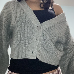 Grå stickad kofta från Divided - Säljer en snygg grå stickad kofta från Divided. Den är croppad med knappar framtill och har en ribbad design. Perfekt nu på våren, säljer pga har en likadan i svart. Cardigan. Skriv vid frågor💕