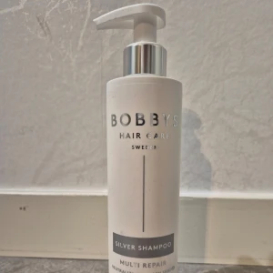 Silver Shampoo från Bobby's Hair Care - Silver Shampoo från Bobby's Hair Care Sweden. Perfekt för att neutralisera gula toner i blont eller grått hår. Kommer i en stilren vit flaska med pump för enkel dosering. Multi Repair-formula som vårdar och stärker håret.