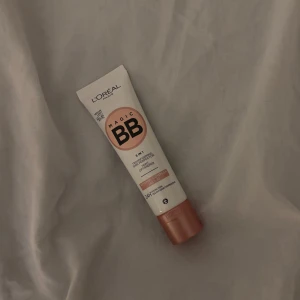 L'Oréal Magic BB Cream - L'Oréal Magic BB Cream i en praktisk tub med skruvlock. Denna BB-kräm är designad för att jämna ut hudtonen och ge en naturlig finish. Perfekt för en snabb och enkel applicering. I färgen MEDIUM LIGHT! (HAR ALDRIG ANDVÄNT)