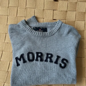 Grå tröja från Morris - Snygg grå tröja från Morris med svart text på bröstet. Tröjan har långa ärmar och ribbade kanter vid hals, ärmslut och nederkant. Perfekt för en stilren look.