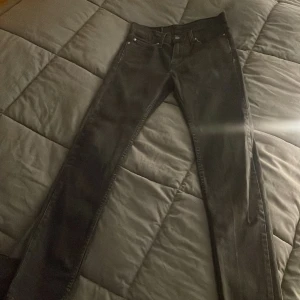 Svarta jeansbyxor - Snygga svarta jeans från Levis med klassisk design. De har en rak passform och är perfekta för en stilren look. Byxorna har både knappar och dragkedja framtill. 