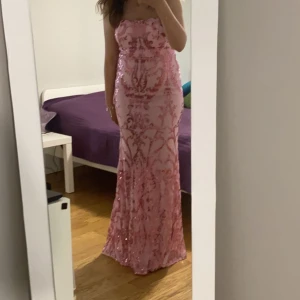 Rosa axelbandslös klänning med paljetter - Elegant rosa axelbandslös långklänning med glittriga paljettdetaljer i ett vackert mönster. Perfekt för en festlig kväll med sin figurnära passform och glamorösa look. Från shein, strl xl men motsvarar m/l