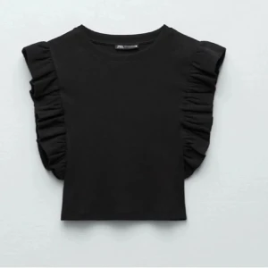 Svart topp med volangärmar från Zara - Snygg svart topp från Zara med volangdetaljer på ärmarna. Storlek S, har en likadan blå, kolla annons💗