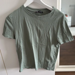 Grön t-shirt från Zara - Säljer en stilren grön t-shirt från Zara. Väldigt bra skick, har stått i skåpet.