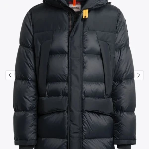 Svart dunjacka från Parajumpers - Snygg svart dunjacka från Parajumpers med huva och långa ärmar. Jackan har en praktisk dragkedja och en ikonisk gul detalj vid halsen. Perfekt för kalla dagar med sin pufferdesign som håller värmen.Doutchbag,Extra knappar och även parajumpers hänge medföljer till,Kvitto finns tillgängligt.:Storlek S men passar även Xs och M beroende på hur man vill den ska sitta 