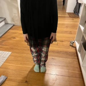 Svart långärmad topp från pompoelux  - Säljer en elegant svart långärmad topp från Pompoelux. Toppen har ett transparent lager som ger en fin effekt och är perfekt för att lägga till en touch av stil till din outfit. Passar bra till både jeans och kjol.