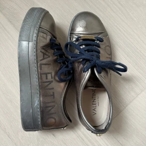 Valentino skor - Dalia luxe platform sneaker, snygga metallicfärgade sneakers från Mario Valentino med mörkblå snörning. Köptes i usa för ett antal år sedan men kommer aldrig till användning. Nypris ca 5000 kr