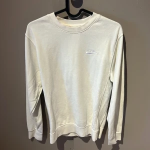 Ljusgul långärmad tröja från Nike - Säljer en stilren ljusgul långärmad tröja från Nike. Tröjan har en klassisk rund halsringning och en diskret Nike-logga på bröstet. Perfekt för en avslappnad look.