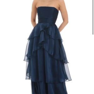 Mörkblå balklänning💙✨✨ - En marinblå klänning, balklänning, ifrån Lucy in the sky. Tyget är skimmrigt nästan glittrigt. Den är axelbandslös med volanger nedtill. Jag har köpt den på Vinted av en tjej, men den är helt oanvänd och har alla lappar kvar! Den är helt slutsåld på hemsidan✨🥰pris kan diskuteras vid snabbt köp!