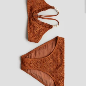 Virkad bikini med prislapp - Ny bikini med prislapp, köpt i våras.  Pärlor på banden.  Aldrig använd.  Nypris: 149  kr