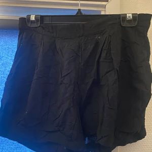Svarta shorts från H&M - Säljer ett par svarta shorts från H&M i storlek 36. De är perfekta för både vardag och fest med sin klassiska svarta färg. Shortsen har en normal passform och är gjorda i ett bekvämt material. Perfekta för sommardagar eller en utekväll!