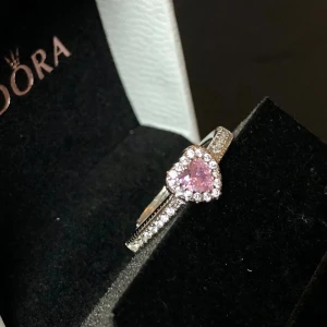 Ring med rosa hjärta  - Gullig mindre ring som är ny och oanvänd  Den går ställa in i storlek så den passar alla  Silver rosa och vit färg  Steel med små kristaller 