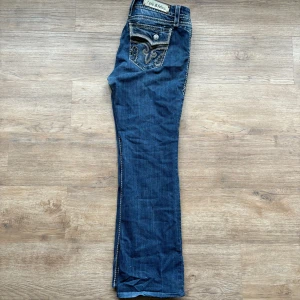 Rock Revival jeans bootcut - Roch revival jeans bootcut. Fit W31 (Yttbenslängd 103 cm) (innerbenslängd 79cm) (midja 44cm) (benöppning 24cm) tveka inte att höra av dig angående bild eller frågor.