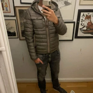 Moncler jacka - Schysst grå moncler dunjacka med dragkedja. Jackan har en quiltad design och är perfekt för kyligare väder Perfekt för både vardag och fest! Moncler SIZE 3 passar m finns nån skrapa inget som påverkar samt ett pin hole som knappt synns