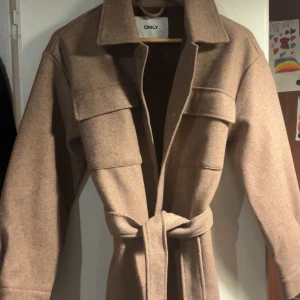 Beige brun kappa  - Säljer denna fina kappa då den inte alls kommit till användning storlek 34 men passar i 36 oxå