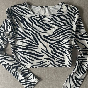 Zebra topp - Använt en gång. Väldigt skönt material. Kortare i modellen så täcker inte hela magen 