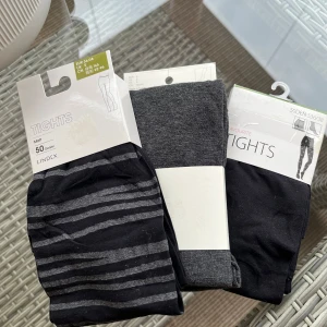 Tre par tights  - Säljer tre par tights, oanvända. Svart/grårandig från Lindex i 50 denier. Grå från H&M i bomull. Svart med prickar från Lindex i polyamid/elestan. Tillsammans 120kr eller 50kr/par