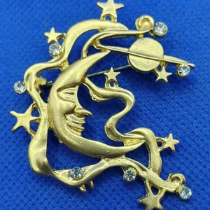 Brosch - Måne med stjärnor och planeter - Den här broschen i form av en måne med stjärnor omkring är ca 5.5 × 4.5 cm.