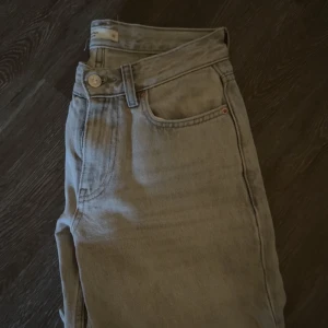 Jeans Gina  - Jeans från Gina Tricot i modellen ”Low straigh jeans” i storlek 32. Färgen är grå. Nypris: 500kr. 