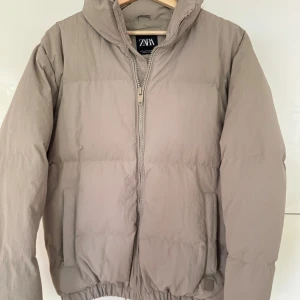 Beige dunjacka - Grymt stilren och skön jacka från Zara, utan några som helst tecken på användning. Strl M Grymt snygg till hösten eller perfekt i värme för vintern och afterski’n. Hör gärna av dig med frågor!