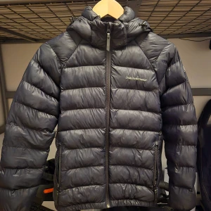 Svart peak jacka - Säljer en snygg och varm svart jacka från Peak Performance. Jackan är i fint skick men finns två defekter(se bild 4-5)  |storlek 160 kan även passa 165||Fint skick| skicka bud|