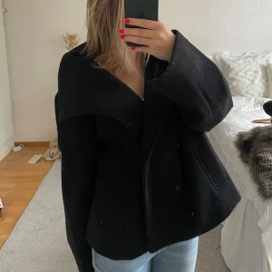 NA-KD kappa svart - svart nakd kappa som är slutsåld, lite nopprig vid ärmarna men annars i fint skick, otroligt fin och perfekt till kallare tider nu!