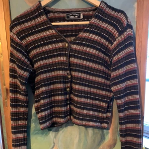 Randig kofta från Sinclair - Säljer en superfin randig kofta från Sinclair i storlek 34/36. Med knappar framtill, varav en har ramlat av.