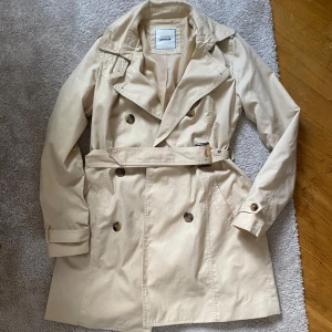 Trenchcoat i beige - Fin trenchcoat i beige i strl S, sparsamt använd 