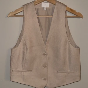 Beige kostyväst - Aldrig använd. Otroligt fin! Bild på mig i en likadan fast i vit för passform!
