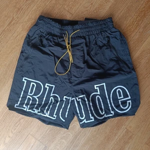 Svarta shorts från Rhude - Säljer ett par oanvända svarta shorts från Rhude i storlek M. De har en loose passform och jag är rätt smal så de var lite breda om benen men annars bra längd.