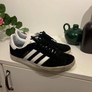 Svarta Adidas Gazelle sneakers - Säljer ett par klassiska svarta Adidas Gazelle sneakers i bra skick. Använt ja men det e bara att torka av dom så e de som nya. Inget hål eller något❤️