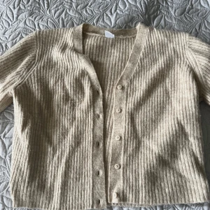 Beige ribbad kofta från Lindex - Säljer en superfin beige ribbad kofta från Lindex i storlek 158/164. Perfekt för höst och vår med sina långa ärmar och knappar framtill. Koftan är i mycket bra skick . 