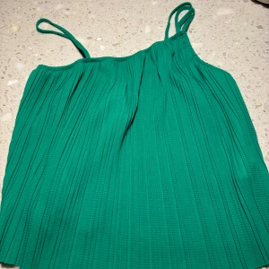 Grön ribbad linnetopp från Bik Bok - Säljer en snygg grön ribbad linnetopp från Bik Bok i storlek S. Perfekt för sommardagar eller en kväll ute. Toppen har smala axelband och en luftig passform. Helt ny med tag kvar! Färgen är som sista bilden!