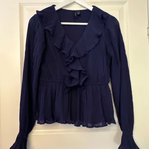 Mörkblå blus från vero moda - Jättefin mörkblå blus från Vero Moda. Blusen är i nyskick då den endast är andvänd 2 gånger. Det finns en knytning i midjan där man kan välja själv hur tight blusen ska sitta.