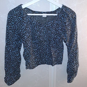 Blommig topp  - Säljer en söt blommig topp från Lindex i svart och blått. Toppen har långa ärmar och ett fint blommönster som passar perfekt för både vår och höst. Den är i mycket bra skick och är perfekt för en casual look eller en dag ute med vänner.💞💞💞