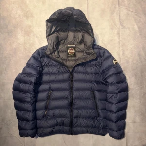 Blå pufferjacka från Colmar - Säljer en snygg blå pufferjacka från Colmar i mycket bra skick. Jackan har en praktisk huva och dragkedja framtill. Perfekt för kyliga dagar och håller dig varm och bekväm. Passar både till vardags och lite mer avslappnade tillfällen. Storleken är M. För mer frågor är det bara att skriva.