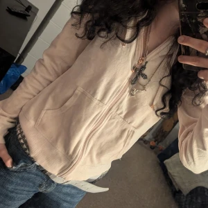 Beige hoodie med dragkedja - Säljer en mysig ljus rosa hoodie med dragkedja framtill. Den har en avslappnad passform 