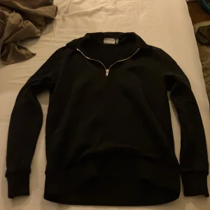 Svart halv zip - Säljer en stilren svart tröja med dragkedja bra skick!
