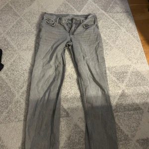 Grå jeansbyxor - Säljer ett par grå jeansbyxor i bra skick. De har en klassisk femficksdesign och är i en straight passform med låg midja.