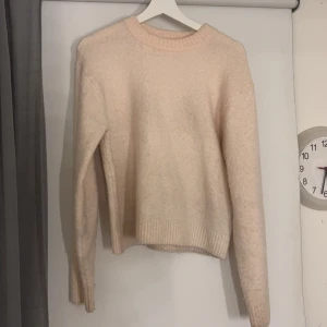 Ljus rosa stickad tröja - Mysig rosa stickad tröja med rund hals och långa ärmar. Perfekt för kyliga dagar och passar till både vardag och fest. Ribbstickade muddar ger en snygg finish. Ett måste i garderoben för höst och vinter! Något nopprig så därför jag säljer billigt. Nypris 300