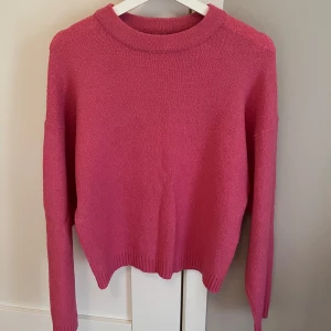 Rosa stickad tröja - Säljer en superfin rosa stickad tröja i mycket bra skick. Tröjan har långa ärmar och en klassisk rund halsringning. Passar perfekt till både jeans och kjol!