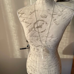 Silverfärgat halsband med lövberlock - Ett elegant silverfärgat halsband med en fin lövberlock. Perfekt för att ge en naturlig touch till din outfit. Kedjan är tunn och smidig, vilket gör den bekväm att bära hela dagen. Passar både till vardags och festliga tillfällen. Längd inklusive berlock 48 cm.