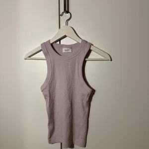 Ljuslila ribbad linnetopp från Gina Tricot - Säljer en superfin ljuslila ribbad linnetopp från Gina Tricot. Perfekt för sommardagar eller som ett lager under en kofta. Toppen är i mycket bra skick och har en tight passform som framhäver figuren. Ett måste i garderoben för en stilren look!
