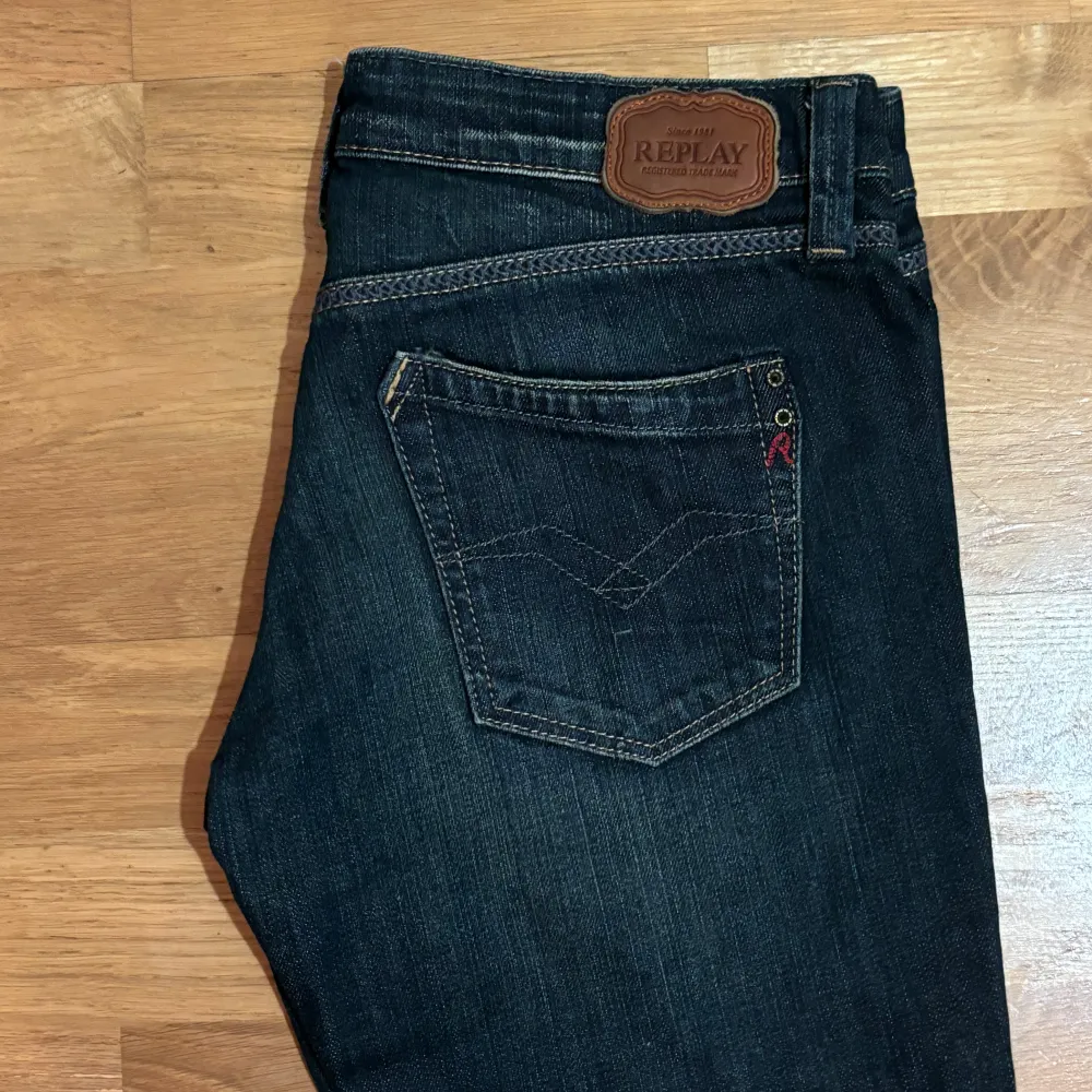 Säljer ett par snygga mörkblå jeans från Replay i modellen Rockxanne. Storlek W28/L34. De har en klassisk femficksdesign och är i bra skick. Perfekta för både vardag och fest! 🖤. Jeans & Byxor.