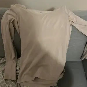 Säljer en stilren beige långärmad topp från H&M i storlek M. Perfekt för både vardag och lite finare tillfällen. Toppen är i ett mjukt och bekvämt material som sitter skönt mot huden. Passar bra till jeans eller kjol för en avslappnad look.